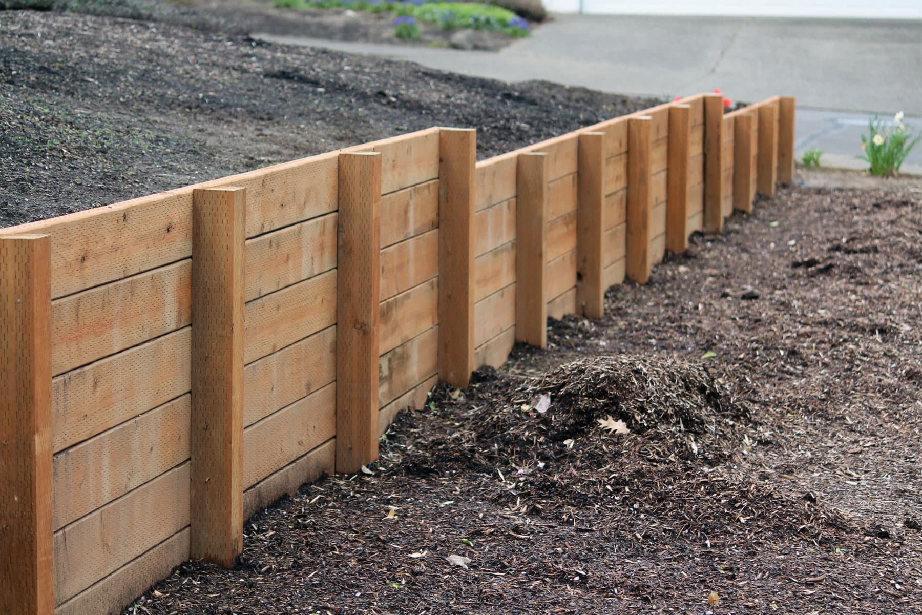 Aging timber retaining wall along a residential driveway (representative photo for Guildford)